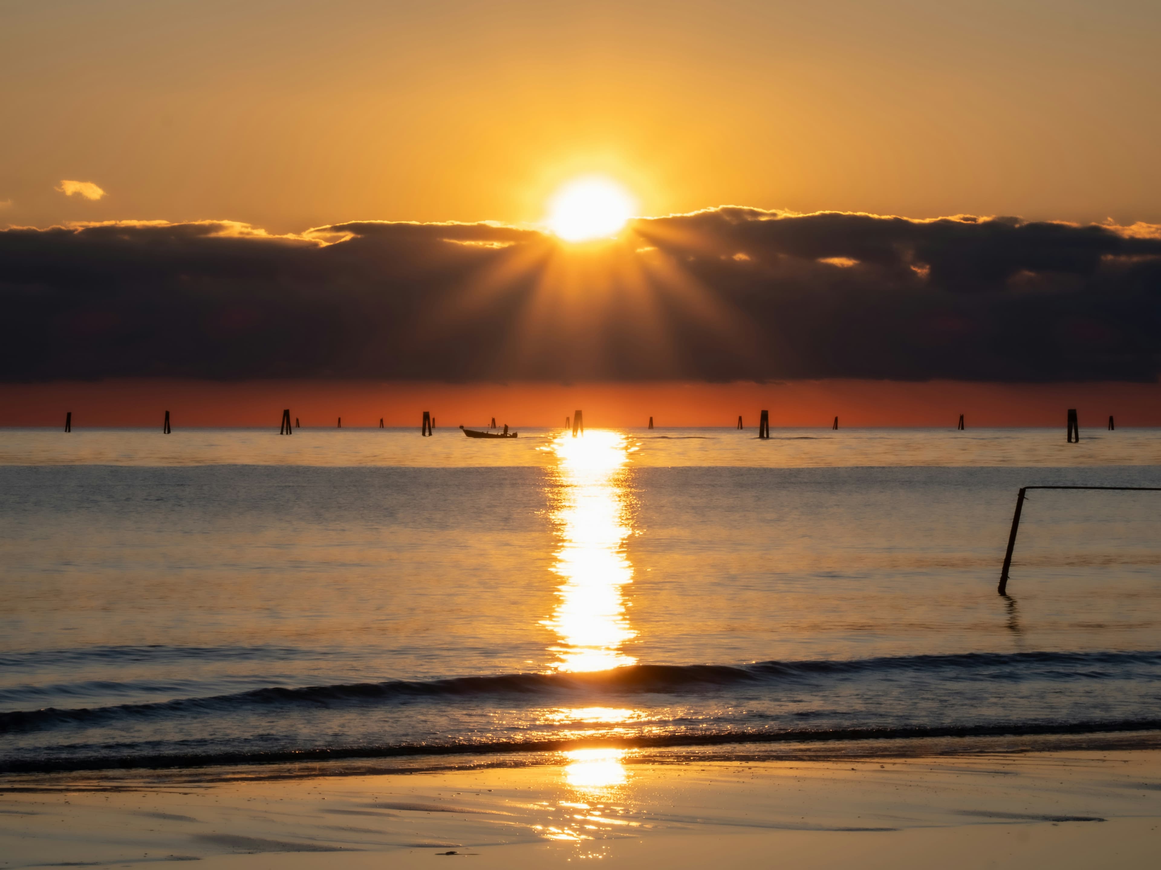 Golden sun rays shining over a calm ocean at sunrise